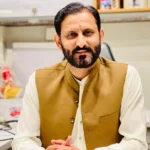 Dr. Raja Imran pediatrician in Rawalpindi sitting in his clinic chamber during consultation hours